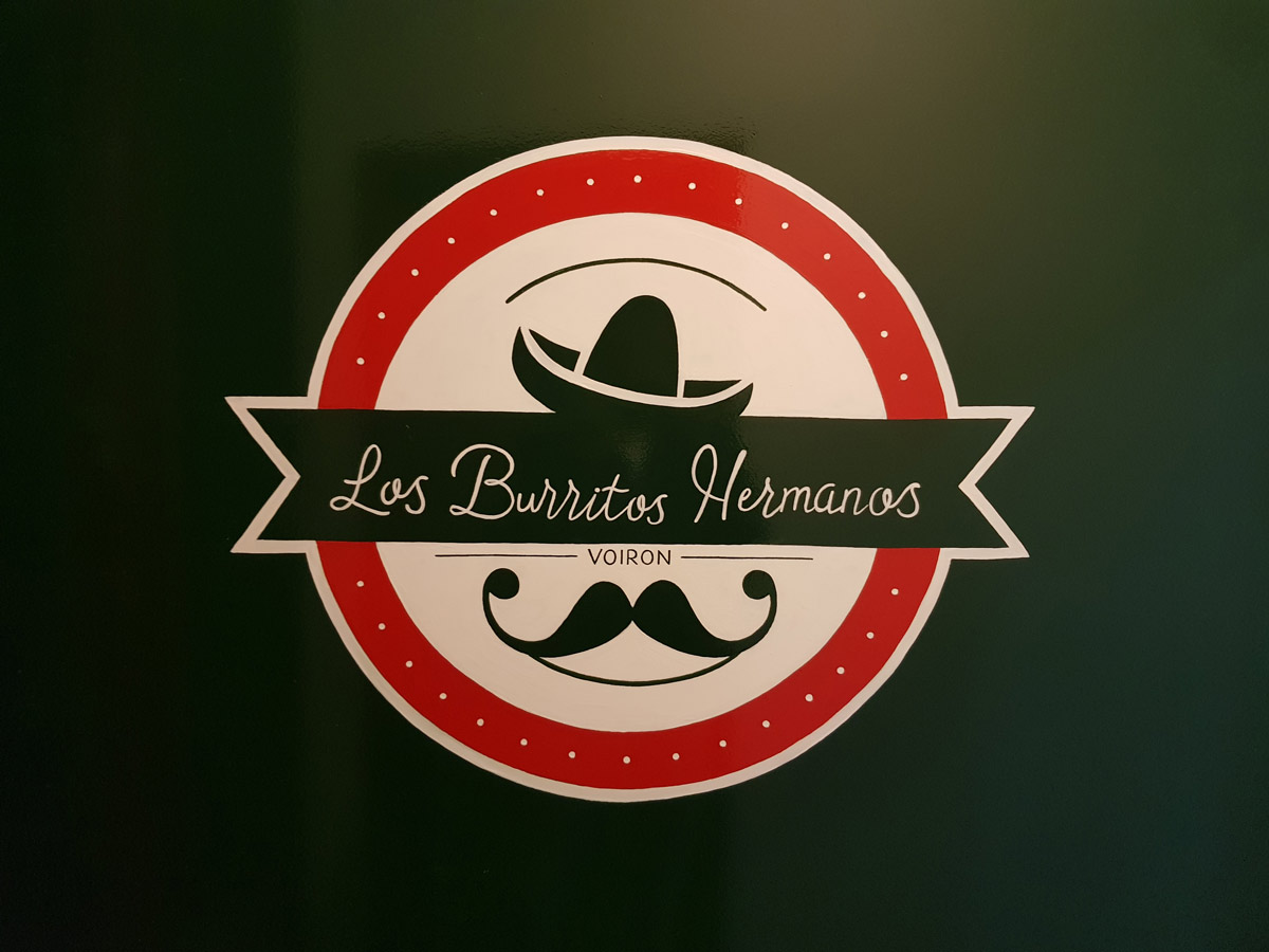 Logo du restaurant - Peinture réalisée sur la vitrine extérieure.